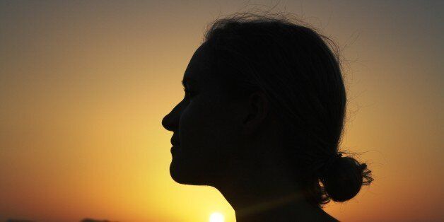 Silhouette of a young woman at sunset