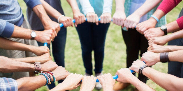 Team connected in circle around plastic hoop