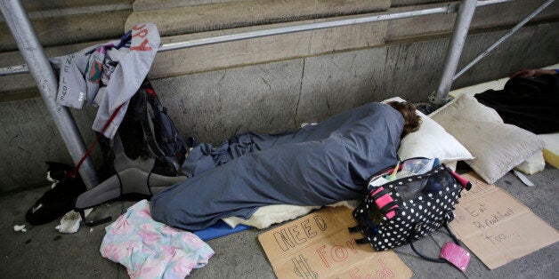 Homeless people sleep on the sidewalk in New York's financial district, Monday, Aug. 19, 2013 in New York. (AP Photo/Mark Len