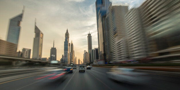 Long exposure photograph captured with a roof-mounted camera on a fast driving car. Streaking city-lights and background.