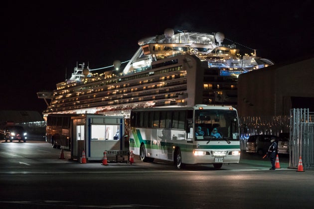 A bus carrying passengers who will take a government charter flight from the quarantined Diamond Princess...