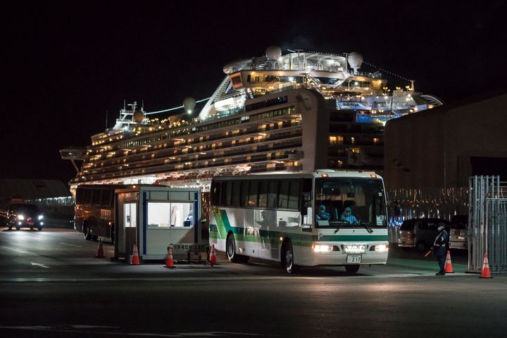 A bus carrying passengers who will take a government charter flight from the quarantined Diamond Princess cruise ship drive at the Daikoku Pier on February 20, 2020 in Yokohama, Japan.