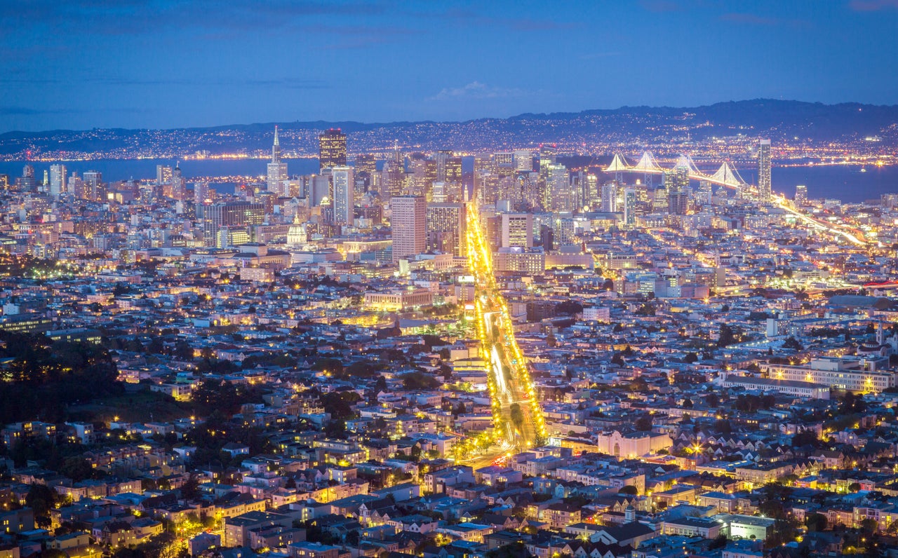 San Francisco at night, with Market Street lit up. Private cars are now banned on the thoroughfare.
