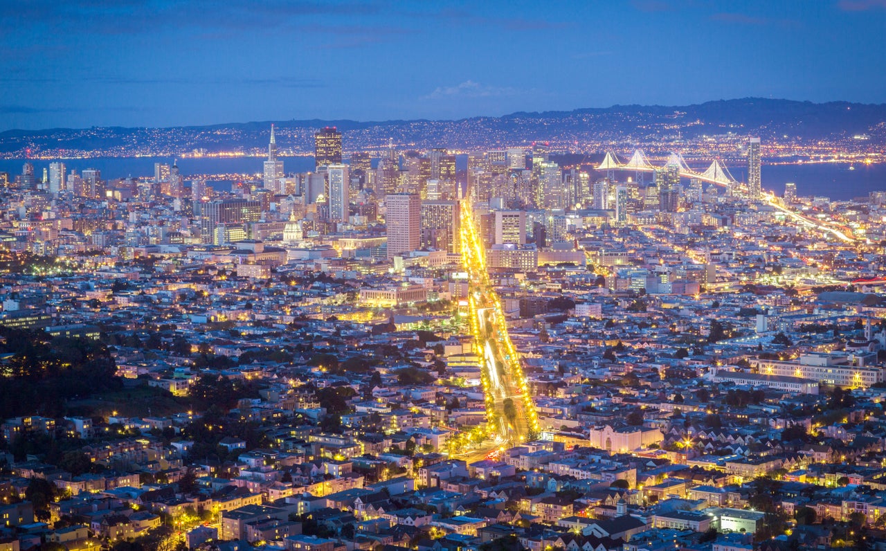 San Francisco at night, with Market Street lit up. Private cars are now banned on the thoroughfare. 