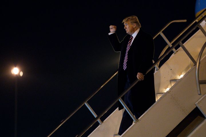 President Donald Trump pumps his fist as he arrives at McCarran International Airport on Feb. 18 in Las Vegas.