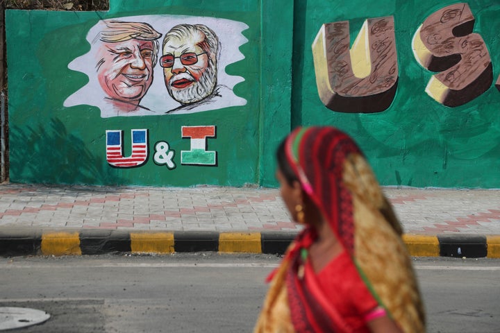 A woman looks at a wall painted with portraits of U.S. President Donald Trump and Prime Minister Narendra Modi in Ahmedabad on Feb. 18, 2020.