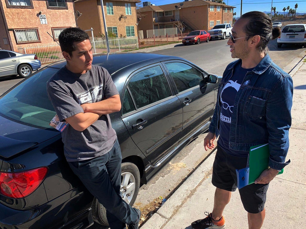 Vaneik Echeverria, right, talks to Adrian Silva, who never votes, about Democratic presidential candidate Bernie Sanders in East Las Vegas.