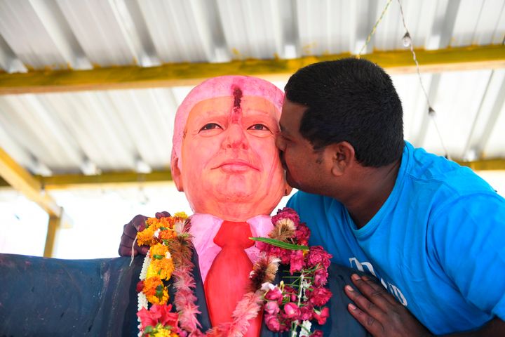 Farmer Bussa Krishna, 33, kisses a statue of US President Donald Trump after offering prayers, at his residence in Jangaon district, some 120 km from Hyderabad on February 17, 2020, ahead of his visit to India.