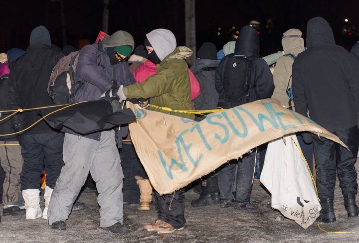 Protesters remove a sign as they leave rail blockade in Saint-Lambert, Que. on Friday.