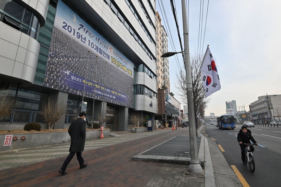 A man wearing a face mask walks in front of the Daegu branch of the Shincheonji Church of Jesus in the southeastern city of Daegu.