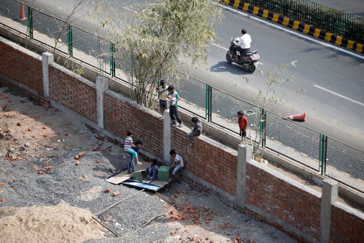 Children play on a wall that was built along a slum area as part of a beautification drive along a route that U.S. President Donald Trump and India's Prime Minister Narendra Modi will be taking during Trump's visit.