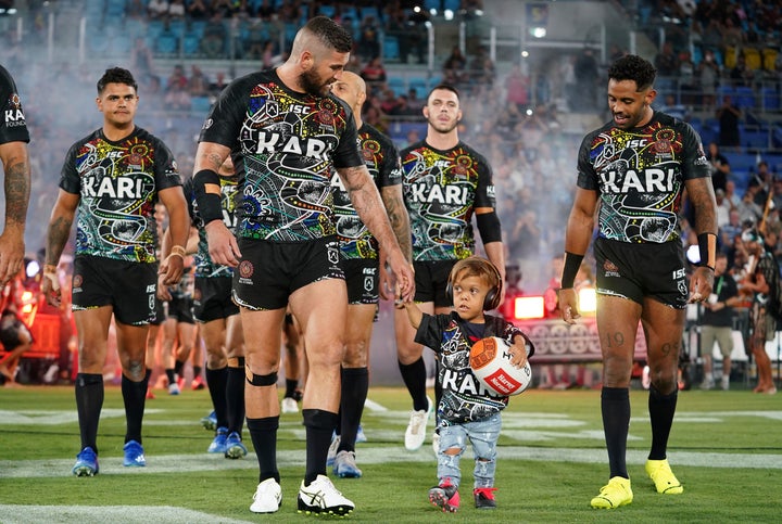 Quaden Bayles leads the Indigenous All Stars on to the field with captain Joel Thompson prior to the NRL Indigenous All-Stars vs. Maori Kiwis match at CBus Super Stadium on the Gold Coast.