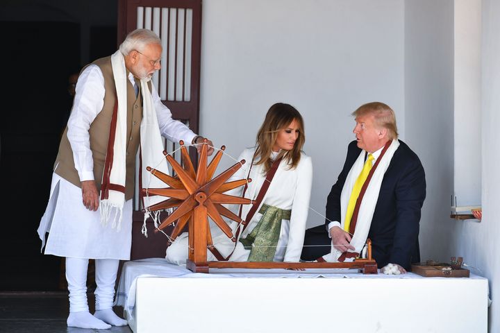 US President Donald Trump and First Lady Melania Trump listen to Prime Minister Narendra Modi (L) as they sit next to a charkha, or spinning wheel, during their visit at Gandhi Ashram in Ahmedabad on February 24, 2020.