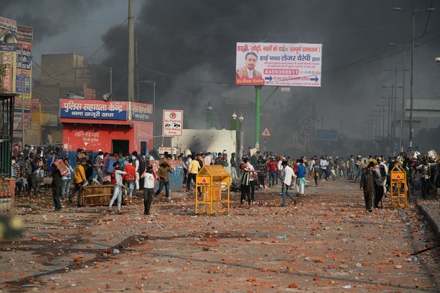 Demonstrators gather along a road scattered with stones following clashes between supporters and opponents...