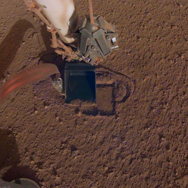 This October 2019 photo made available by NASA shows InSight's heat probe digging into the surface of Mars. On Thursday, Oct. 17, 2019, NASA says the drilling device has penetrated three-quarters of an inch (2 centimeters) over the past week, after hitting a snag seven months ago. While just a baby step, scientists are thrilled with the progress.  (NASA/JPL-Caltech via AP)