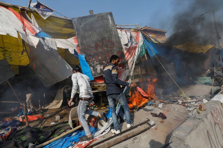 People supporting the new citizenship law destroy the protest site used by those opposing it, in New Delhi, February 24, 2020.