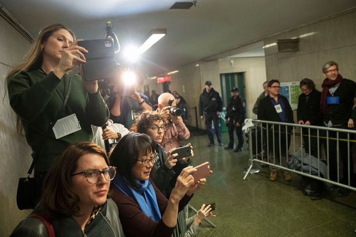 New York Post reporter Rebecca Rosenberg, top, CBS Network News producer Cassandra Gauthier, left, Court TV producer Grace Wong, second from left, Vulture magazine freelance reporter Victoria Bekiempis, third from left, and New York Daily News reporter Molly Crane-Newman, use their phones to film Harvey Weinstein leaving for the day during his rape trial, Wednesday, Feb. 19, 2020, in New York. 