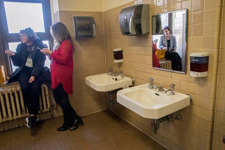 Vulture magazine freelance reporter Victoria Bekiempis, left, Fox News field producer Marta Dhanis, center, and New York Daily News reporter Molly Crane-Newman, take a break from Harvey Weinstein's rape trial in the women's restroom, Wednesday, Feb. 19, 2020, in New York. 