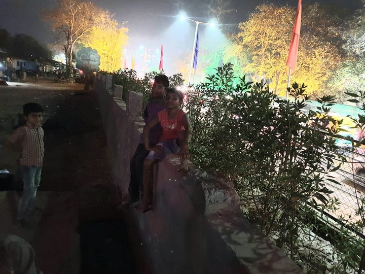 Children sit on the wall that was constructed to hide the Sharaniyavas slum ahead of Trump's visit to Ahmedabad.