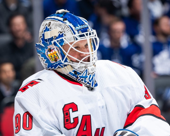 David Ayres smiles through his goalie mask during game action between the Carolina Hurricanes and Toronto Maple Leafs on Saturday in Toronto. The 42-year-old became the oldest goalie in NHL history to win in his debut.