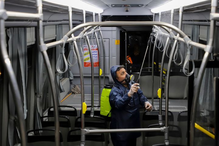 A worker disinfects a public bus against coronavirus in the city of Ahvaz in southwestern, Iran, in early morning of Tuesday, Feb. 25, 2020. 