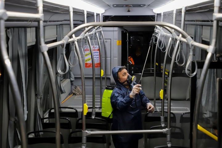 A worker disinfects a public bus against coronavirus in the city of Ahvaz in southwestern, Iran, in early morning of Tuesday, Feb. 25, 2020.