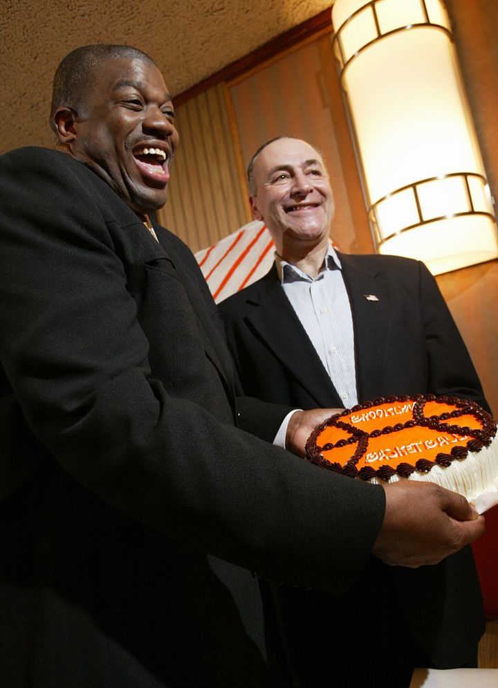Sen. Chuck Schumer poses with basketball player Bernard King and a Junior's cheesecake during a press conference focused on moving the New Jersey Nets to Brooklyn in 2004.