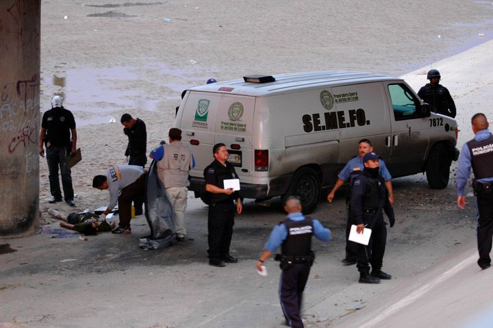 Mexican forensic experts examine the body of Sergio Hernández under the Paso Del Norte border bridge in the city of Ciudad Juarez, Mexico, in June 2010.
