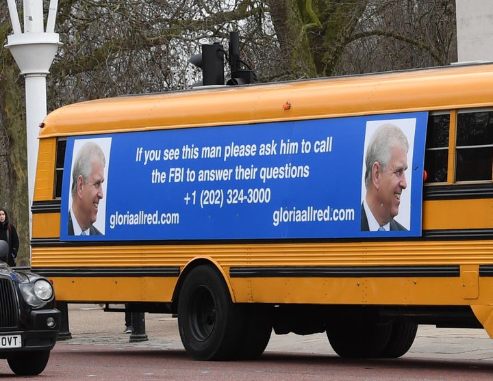 A yellow school bus with a message for the Duke of York from U.S. lawyer Gloria Allred drives along The Mall toward Buckingha