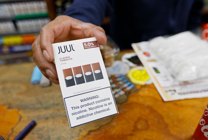 A cashier displays a packet of tobacco-flavored Juul pods at a store in San Francisco.