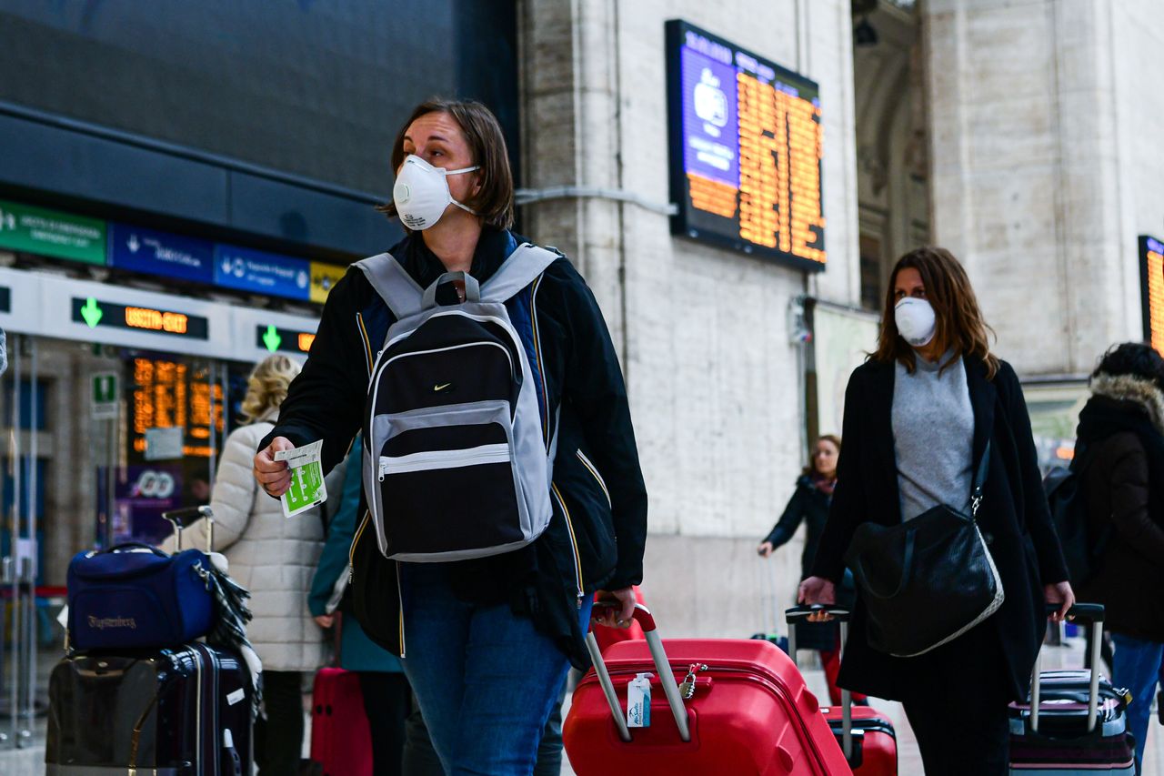 Passengers at Milano Centrale Train Station wear protective respiratory masks as restrictive measures are taken to contain the outbreak in Italy.