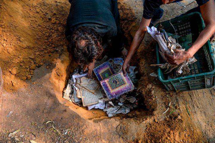People bury copies of the Koran after they recovered from a burnt mosque on February 26. 