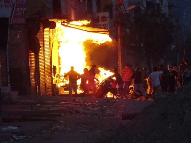A shop burns as a mob sets it on fire during violence between two groups in New Delhi, India, on Feb. 25, 2020.