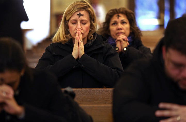 A woman prays after receiving ashes at St. Anthony Shrine in Boston on Ash Wednesday 2018.