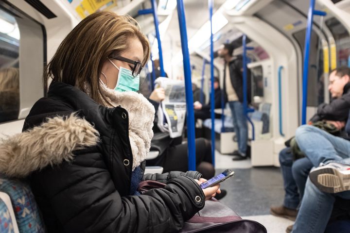A woman wearing a facemark on the London Underground.
