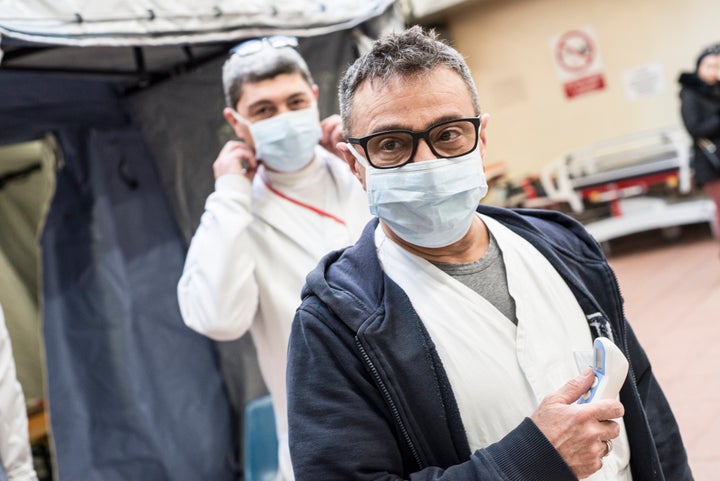 With the exceptions of health-care workers, like these two at the Molinette Hospital in Turin, Italty, and people who are exhibiting symptoms of respiratory illness, face masks are not recommended.