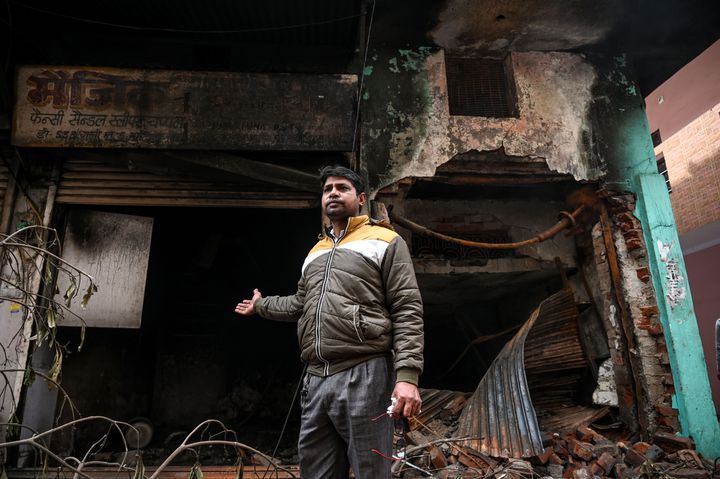 A footwear shop owner in Ashok Nagar shows his burnt shop.