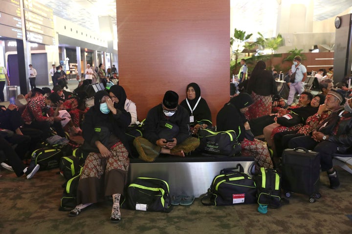 Indonesian who are scheduled to travel to Saudi Arabia for a minor pilgrimage, called 'Umrah', sit at a waiting area as they