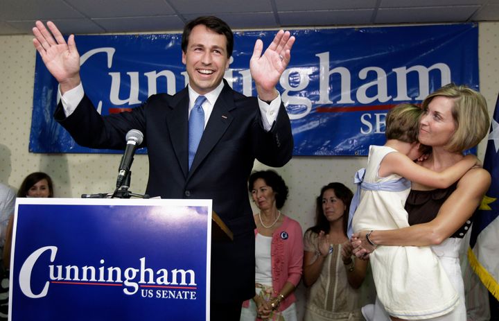 Democratic U.S. Senate candidate Cal Cunningham, left, acknowledges supporters as his wife Elizabeth, right, with their daughter, Caroline, looks on.