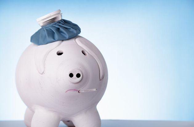 Big piggybank with an ice bag and thermometer is looking sick and sad
