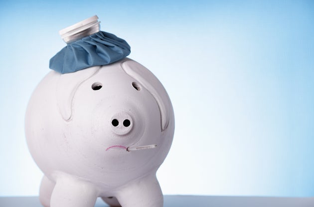 Big piggybank with an ice bag and thermometer is looking sick and