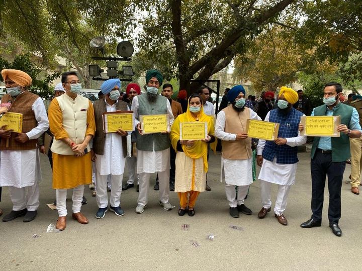 MLAs of AAP Punjab wearing masks at the Punjab Vidhan Sabha on Friday. Taking a jibe at Punjab Chief Minister Captain Amarinder Singh for delay in providing free smartphones to the youths, AAP said that the government is infected with 'Karo Na' virus. 