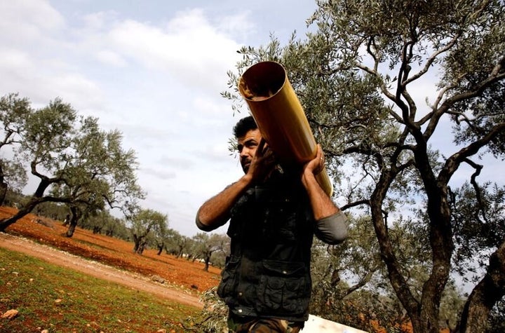 Μαχητής μεταφέρει στον ώμο κάλυκα από βαρύ βλήμα στην περιοχή του Ιντλίμπ.