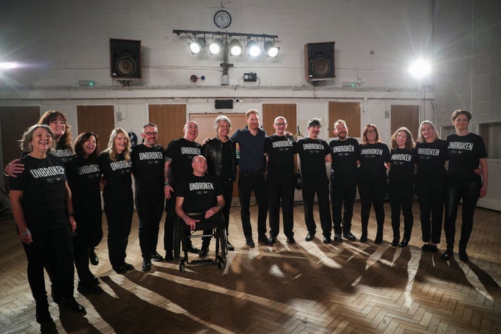 The two pose with members of the Invictus Games Choir. 