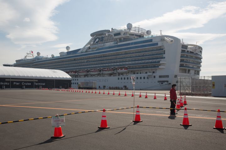 A guard stands at a restricted area in front of the Diamond Princess cruise ship in Yokohama