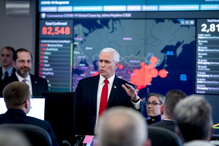 A large monitor displaying a map of Asia and a tally of total coronavirus cases, deaths, and recovered, is visible behind Vice President Mike Pence, center, and Health and Human Services Secretary Alex Azar, left, as they tour the Secretary's Operations Center following a coronavirus task force meeting at the Department of Health and Human Services Feb. 27 in Washington.