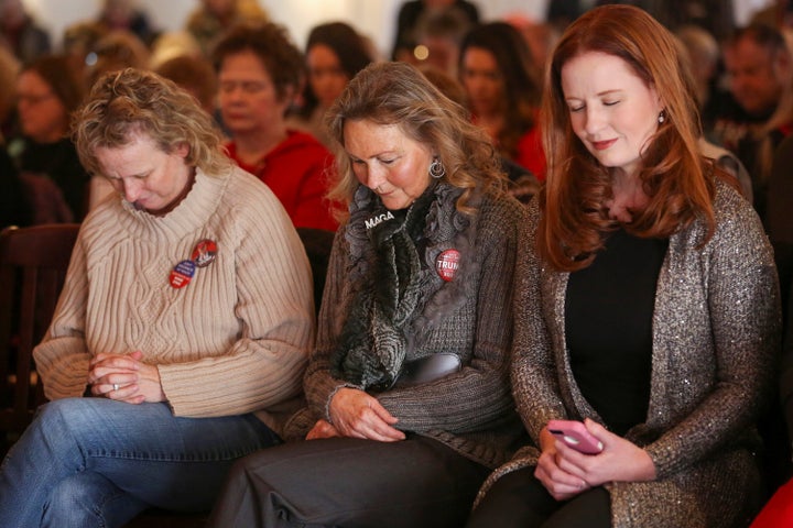 Supporters bow their heads in prayer at a Women for Trump bus tour stop in Sioux City, Iowa, on Jan. 16.
