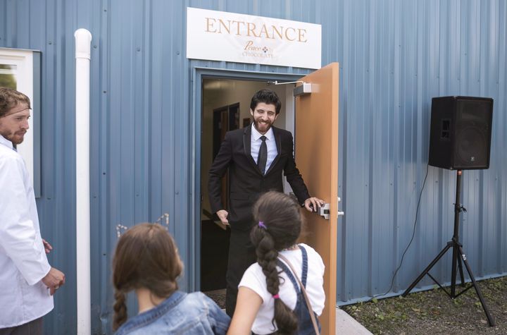 Syrian chocolatier Tareq Hadhad greets children at the door of Peace By Chocolate factory in Antigonish, N.S. on Sept. 9, 2017. 