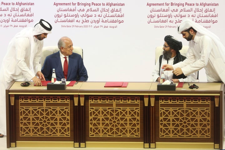 U.S. peace envoy Zalmay Khalilzad, left, and Mullah Abdul Ghani Baradar, the Taliban group's top political leader signed a peace agreement between Taliban and U.S. officials in Doha, Qatar, on Saturday.