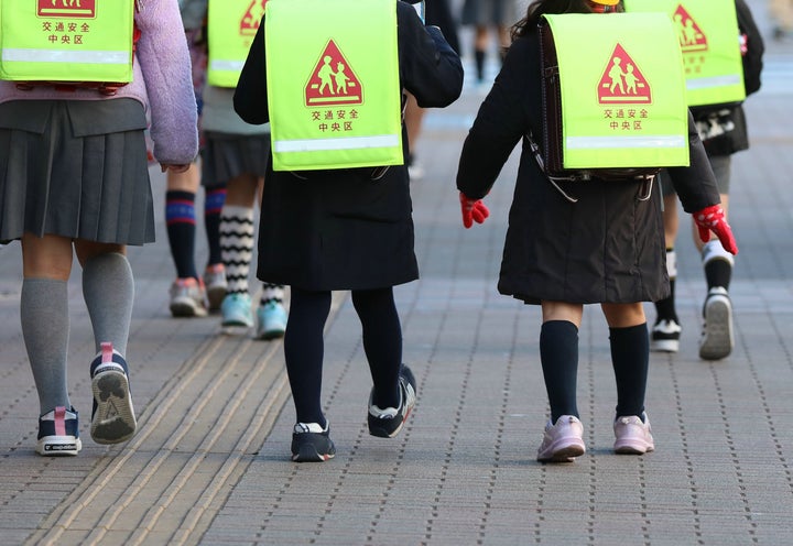 登校する小学校の児童ら。政府は週明けから臨時休校とするよう呼び掛けている。